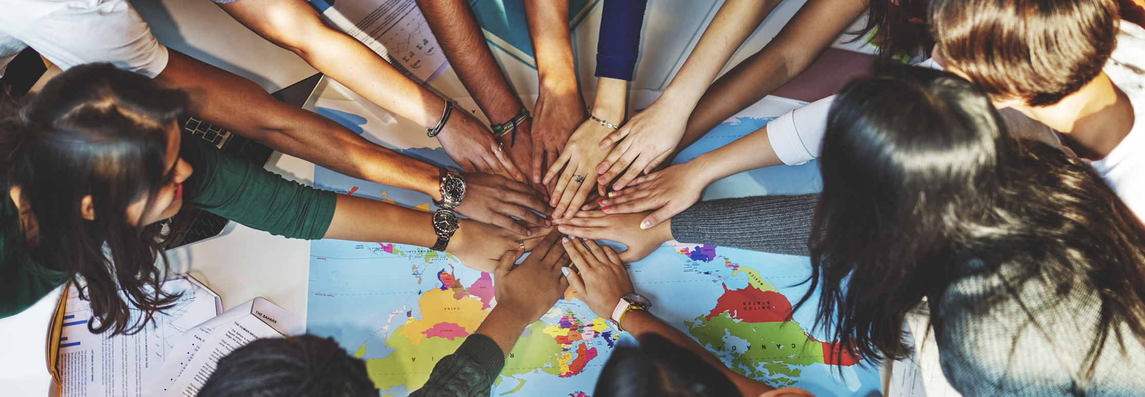 a group of hands reaching towards the center